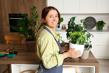 Female gardener with green plants in kitchen