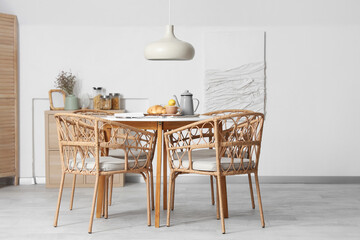 Interior of light room with dining table served for breakfast