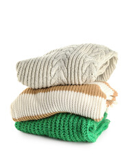 Stack of new different stylish sweaters on white background