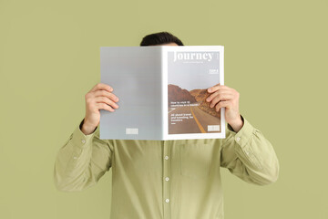 Handsome man reading magazine on green background