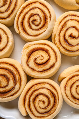 Uncooked cinnamon rolls on baking dish, closeup