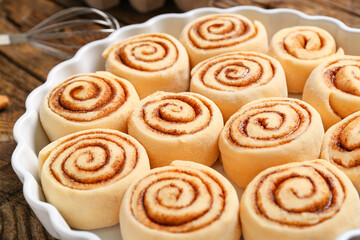 Baking dish with uncooked cinnamon rolls on table