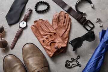 Composition with leather male gloves and stylish accessories on grunge background