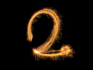 Alphabet and Number two sparklers on black background by light painting.number 2 sparkling golden...