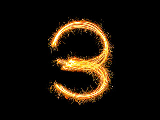 Alphabet and Number three sparklers on black background by light painting.number 3 sparkling golden for party and Celebrate