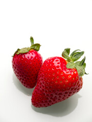 Two ripe strawberries on white.