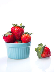 High key photo of strawberries in blue bowl.