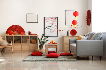 Coffee table with tangerines and cushions on floor in festive living room. Chinese New Year...