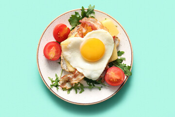 Toast with tasty fried egg, tomatoes and arugula on turquoise background