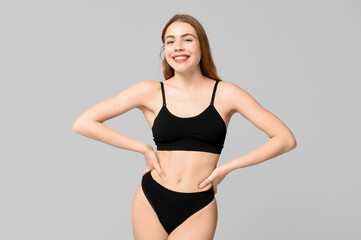 Fototapeta premium Pretty young woman in black cotton underwear on light background