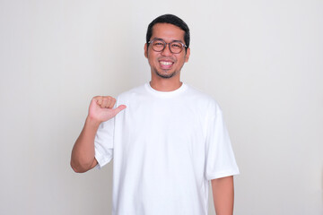 Adult Asian man smiling at the camera with one hand pointing at himself