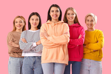 Portrait of beautiful women with crossed arms on pink background