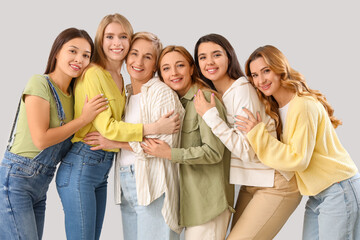 Beautiful hugging women on grey background