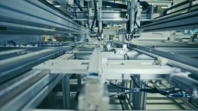 Production of solar panels. Automated equipment at work inside the modern industrial plant.
Aluminum gluing.  4k