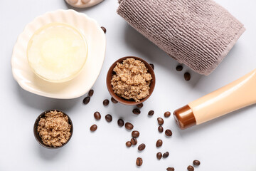 Scrubs with cream, towel and coffee beans on white background. Body massage concept