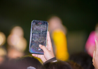Fan taking photo of concert at festival