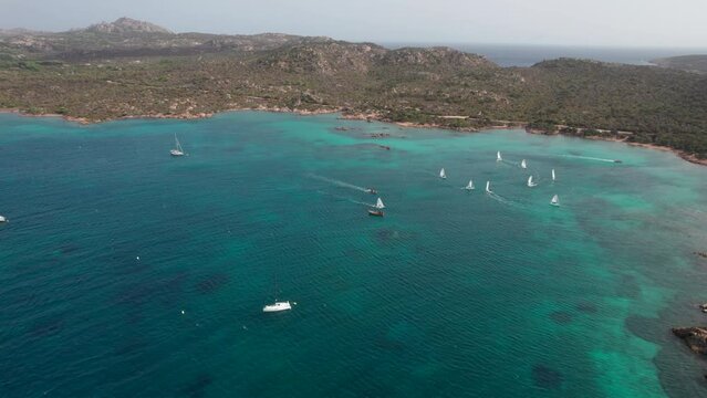 Wonderful aerial view with circular motion over sailboats sailing on the island of Caprera in Sardinia. Cala Conchiglia.