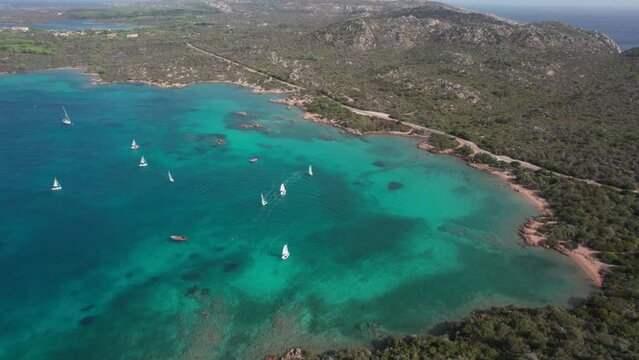 Orbital aerial view of sailboats sailing on the island of Caprera in Sardinia. Cala Conchiglia.