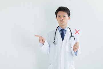 バツのプレートを持った医師　Doctor	