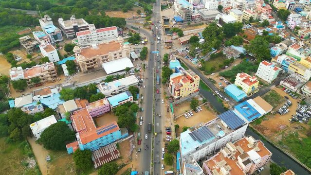 Tiruchirappalli intersection with moving vehicles and surrounding buildings, aerial view. Tamil Nadu, India