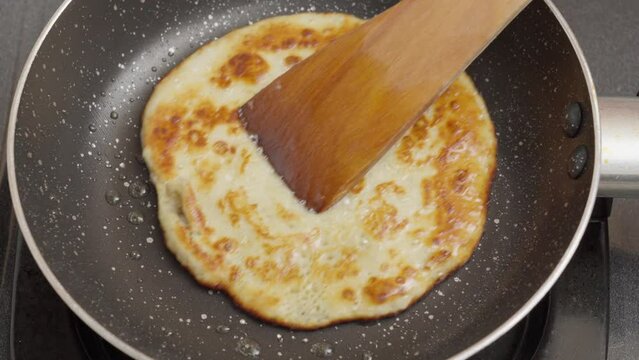 Flipping, evenly cooked and golden-brown surface on both sides of the pancake