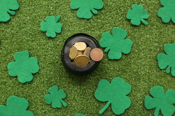 Pot with golden coins and clovers on grass. St. Patrick's Day celebration
