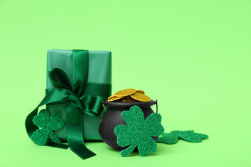 Pot with golden coins, gift box and clovers on green background. St. Patrick's Day celebration