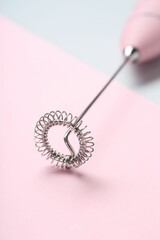 Pink milk frother wand on color background, closeup