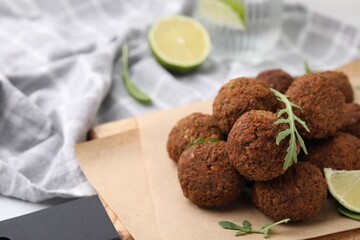 Delicious falafel balls and arugula on table, closeup. Space for text