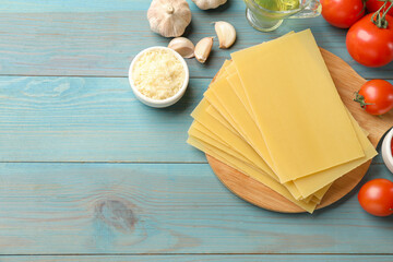 Ingredients for lasagna on blue wooden table, flat lay. Space for text