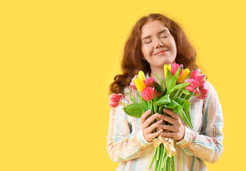 Young woman with bouquet of beautiful tulips on yellow background. International Women's Day