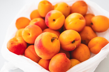 bunch of fresh apricots straight from the farmers' market in plastic bag