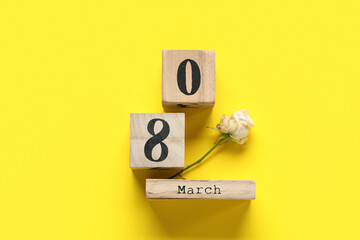 Cube calendar with date 8 MARCH and beautiful rose on yellow background. International Women's Day