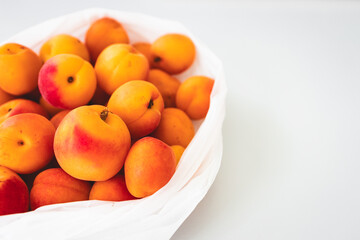 bunch of fresh apricots straight from the farmers' market in plastic bag