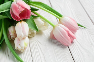 Bouquet of beautiful tulips on white wooden background. International Women's Day