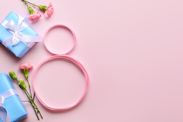 Figure 8 made of ribbon with gift boxes and beautiful flowers on pink background. International Women's Day