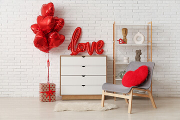 Festive living room interior with grey armchair, word LOVE on chest of drawers and heart-shaped balloons. Valentine's Day celebration
