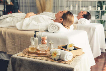 Obraz na płótnie Canvas Aromatherapy massage on daylight ambiance or spa salon composition setup with focus decor and spa accessories on blur woman enjoying blissful aroma spa massage in resort or hotel background. Quiescent
