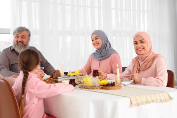 Young Muslim woman having family dinner at home. Ramadan celebration