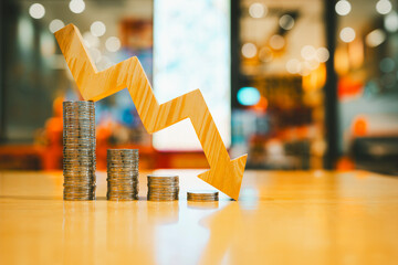 A pile of money and a arrow pointing down symbolizes falling currency and falling interest rates,...