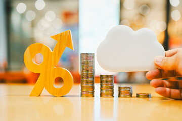 Percentage symbol with an arrow pointing up and  a pile of money and a cloud symbol. This is a...