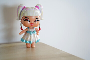 Funny cute girl's figurine toy with big smile on minimalist background