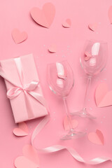 Composition with gift box, paper hearts and glasses for Valentine's Day celebration on pink background