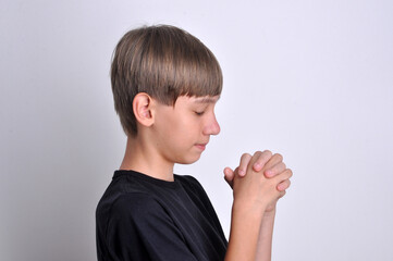 menino com mãos juntas em oração, fé cristã 