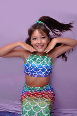 menina sorridente com roupa de sereia em cenário fundo do mar, ensaio de aniversário temático...