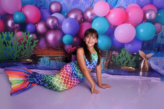menina sorridente com roupa de sereia em cenário fundo do mar, ensaio de aniversário temático sereia linda 