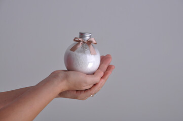 mão segurando frasco com sais de banho 