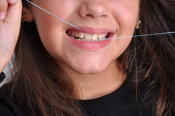 criança menina passando fio dental nos dentes, limpeza e higiene dental 