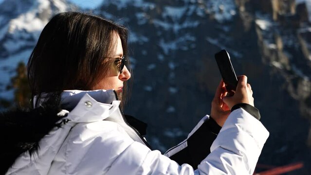 Female tourist in Switzerland hold phone and take photos of nature landscape