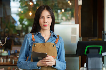 Businessman, cafe, small business, beautiful Asian woman wearing navy blue shirt and brown apron,...